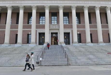 Pedestrians walk past the Widener Library at Harvard University campus after recent news about disciplinary actions resulting from the cheating scandal. JOSH REYNOLDS FOR THE BOSTON GLOBE (Metro, Landergan)
